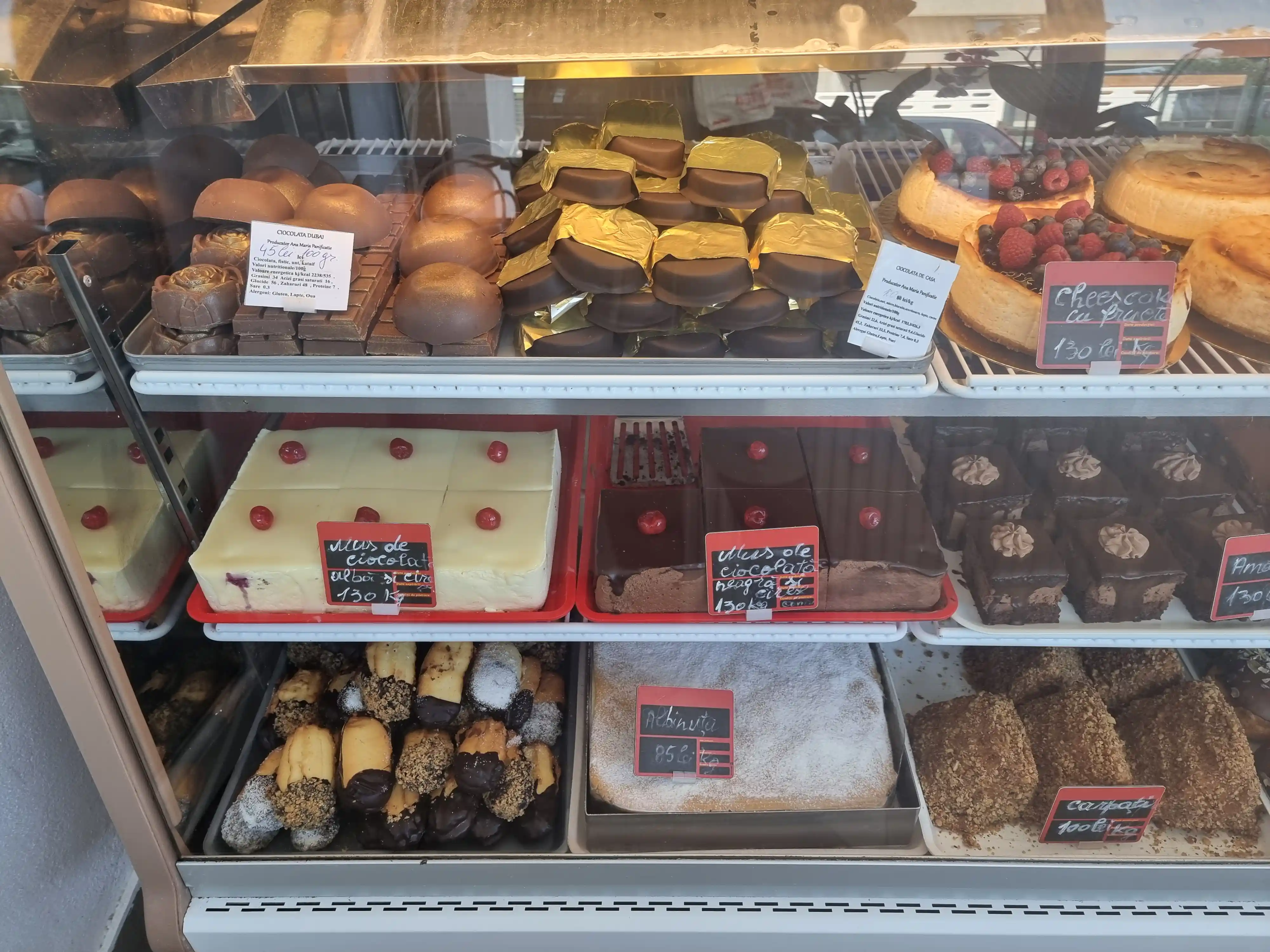 Vitrină frigorifică cu prăjituri de casă: cheesecake cu fructe, amandine și mousse de ciocolată